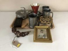 A tray of pewter tankards, trivets, hanging scales, bakelite cased weight,