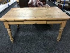 A stripped pine kitchen table fitted a drawer