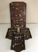 Four wooden spoon racks and a collection of assorted crested spoons