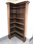 An antique mahogany corner bookcase