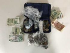 A leather case containing pre-decimal and decimal coins, pennies, six pence pieces, £1 notes etc.