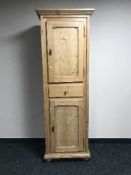 A stripped pine double door cupboard