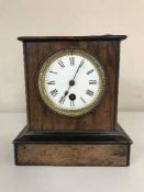 An antique mahogany and pine mantle clock with enamelled dial,
