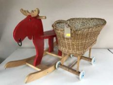 A child's rocking Moose toy and a wicker doll's pram