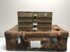 A vintage leather luggage case together with a desk top four drawer index chest