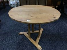 A circular pine pedestal coffee table