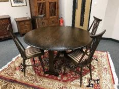 An Ercol elm drop leaf dining table and four wheel backed chairs with striped cover