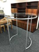 A circular contemporary glass topped clothes rail