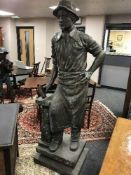 An impressive bronze statue depciting a blacksmith with hammer on plinth,