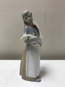 A Lladro figure of a girl carrying a pig
