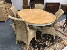 A contemporary pedestal dining table and four Lloyd loom chairs