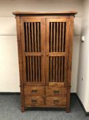 A hardwood double door wardrobe fitted with four drawers