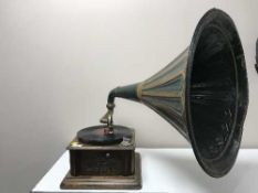 An antique table top gramophone with metal horn and winding handle