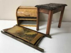 A carved eastern hardwood stool together with a folding two-way fire screen depicting highland