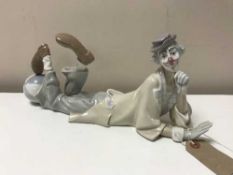 A Lladro figure of a Clown lying with foot on a ball