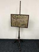 A Victorian mahogany pole screen on claw and ball feet