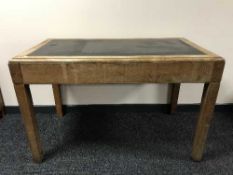 A twentieth century oak leather topped writing table