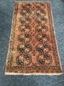 A Persian fringed woollen rug on rust ground
