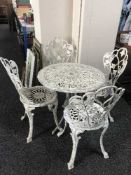 A circular metal garden table and four chairs