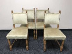 An antique oak dining table and four chairs in beige fabric