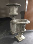 A pair of classical garden urns on stands (one with plinth)