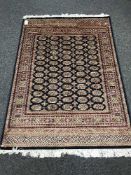 A Persian Bokhara rug on blue ground, 190cm by 140cm.