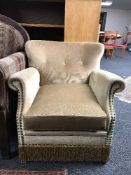 A mid 20th century armchair in gold button dralon