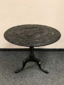 A Georgian carved oak tilt-top table on pedestal support