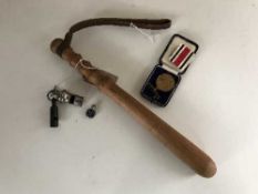 A policeman's truncheon and a bag of cased defence medal and two whistles