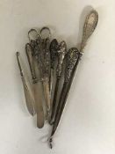 Four silver handled button hooks, scissors,