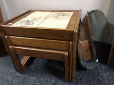 A nest of teak tables and an un-framed mirror