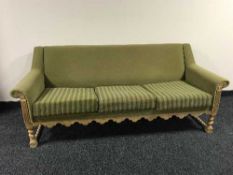 A blonde oak framed three seater settee in green fabric
