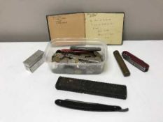 A basket of British and Foreign coins, pen knives, cut throat razor,