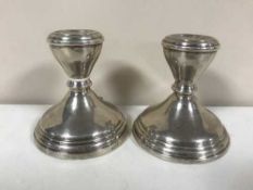 A pair of loaded silver dwarf candlesticks