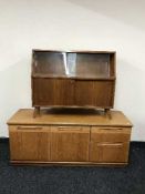A teak low sideboard and glass door bookcase
