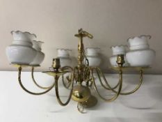 A brass eight branch chandelier with six glass shades