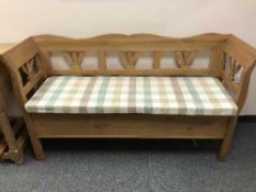 A pine settle, with cushion, width 162 cm.