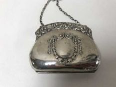 An embossed silver purse on chain