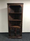 A hardwood corner cabinet with metal handles and fittings