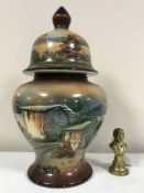 A brass Lord Wellington paperweight and a vase and cover decorated with a landscape