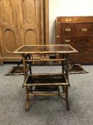 A Victorian aesthetic period lacquered bamboo occasional table, with four fold-out panels,