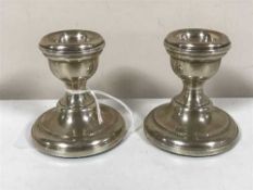 A pair of loaded silver dwarf candlesticks