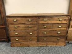 A pine draper's side-by-side chest of eight drawers, with brass handles, width 168 cm.