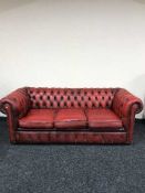 An oxblood three seater Chesterfield settee