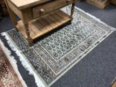 A fringed Persian Bokhara rug, on green ground, 190 cm x 140 cm.