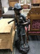 A bronze statue modelled as a boy holding a fish, height 140 cm.