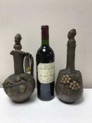 Two pottery decanters embossed with grapes and a bottle of Chateau Tour du Vieux Castel 1998 Saint