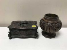 A carved wooden table box containing a pipe and a hardwood brass lined vase
