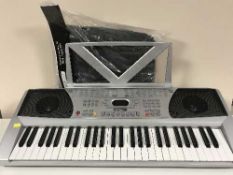 An Acoustic Solutions electric keyboard and charger plus a keyboard bag