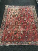 A fringed Persian Erivan design rug on red ground